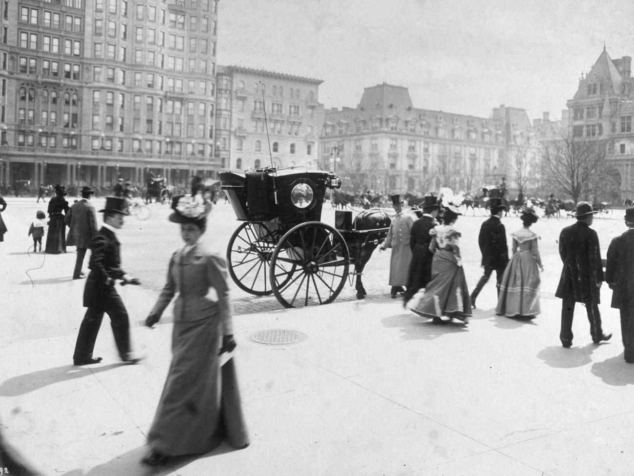 Men And Women Walk On Fifth Avenue In Front Of The Plaza Hotel Between 57Th And 59Th Streets, As A Horsedrawn Carriage Sits By The Curb, 1898