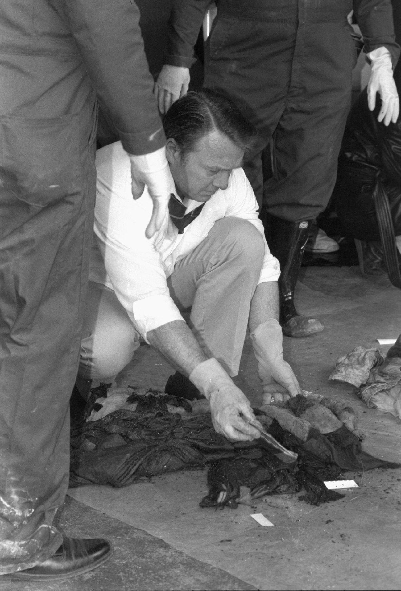 Police Detective Sorts Through Clothing From Some Of The 87 Victims Of The Fire At The Happy Land Social Club In The Bronx.