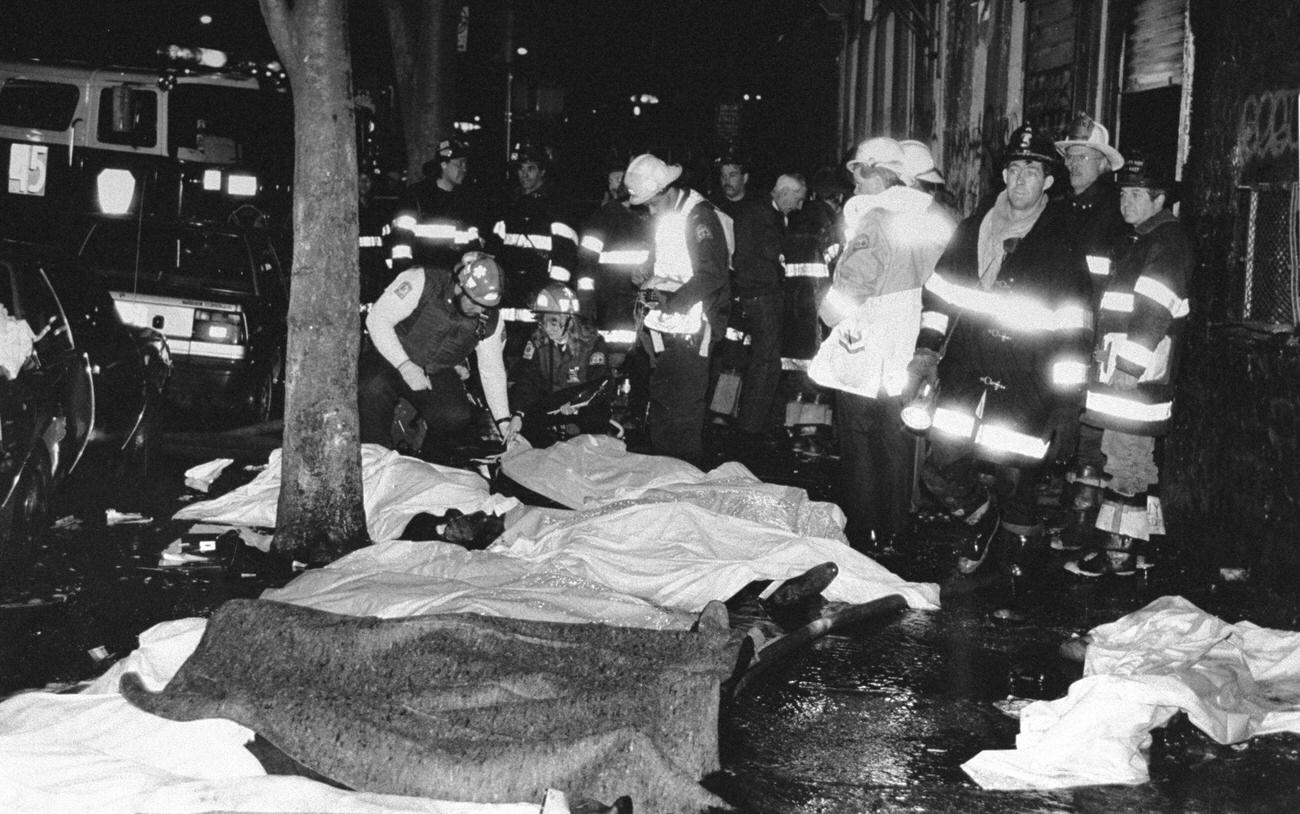 Firefighters Stand Near Bodies Of Some Of The 87 Victims Of A Fire Outside The Happy Land Social Club In The Bronx.