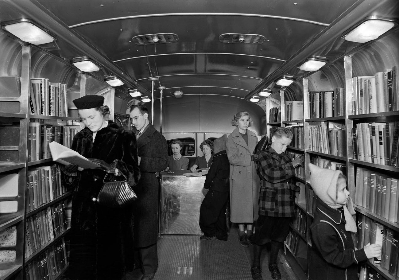 Readers At Book Shelves In The Book Bus. Queens Borough Public Library