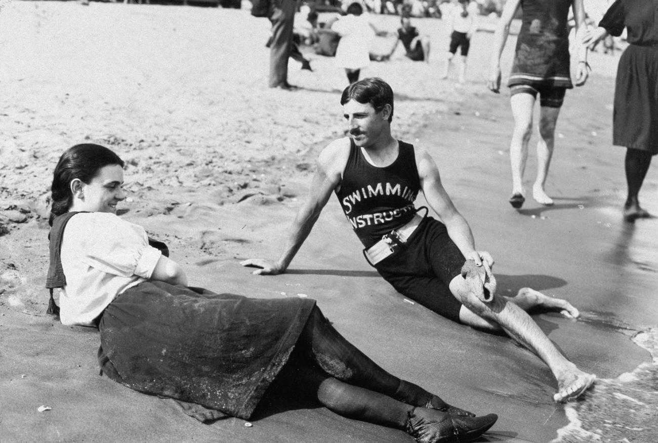 A Bathing Suit-Clad Woman And A Swimming Instructor Lying Close To The Surf On Midland Beach, Staten Island, 1899