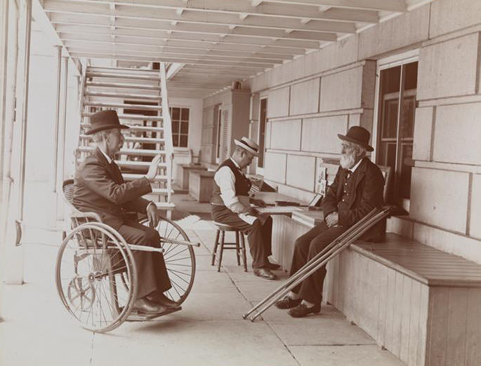 Men, One In A Wheel-Chair, Outside At Sailor'S Snug Harbor, A Facility And Home For Retired Sailors On Staten Island, 1890S