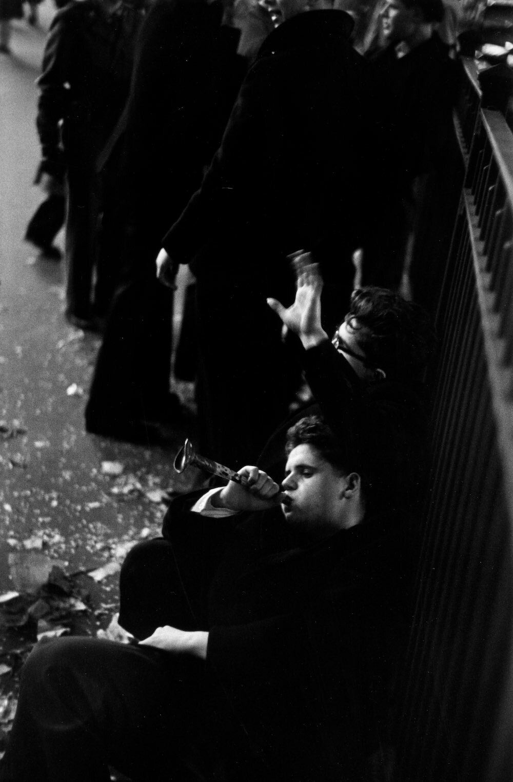 A young man slumped against railings blows on a battered toy trumpet during New Year’s celebrations in Times Square, New York.