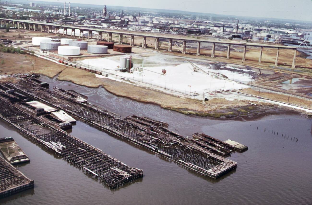 Petroleum Shipping Terminal At Perth Amboy On The Arthur Kill, Showing Oil Slick From Spill. In The Background Is The Outerbridge Crossing To Staten Island, 1970S