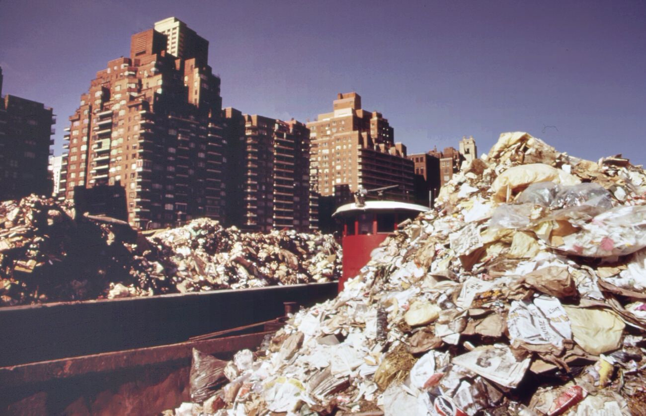 Part Of The 26,000 Tons Of Solid Waste That New York City Produces Each Day. Tugs Tow Heavily-Laden Barges Down The East River To The Overflowing Staten Island Landfill, 1970S