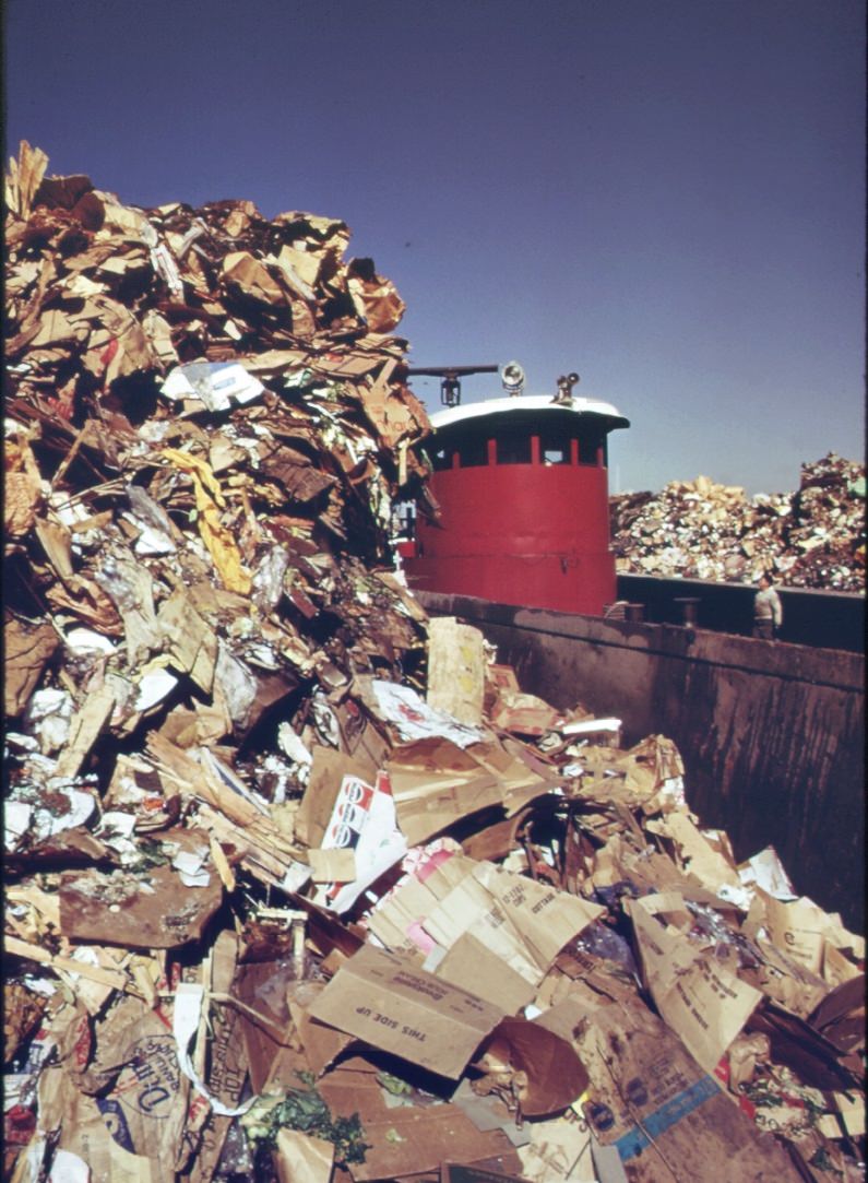 Part Of The 26,000 Tons Of Solid Waste That New York City Produces Each Day. Tugs Tow Heavily-Laden Barges Down The East River To The Overflowing Staten Island Landfill, 1970S