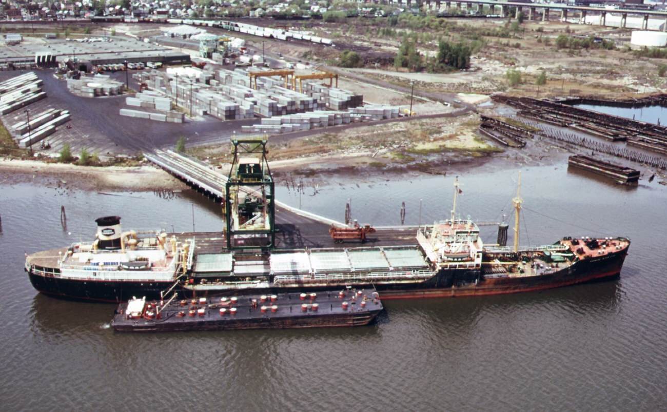 Chemical And Containerized Shipping Of The Union Carbide Company In The Arthur Kill. In The Background Is The Outerbridge Crossing To Staten Island, 1970S