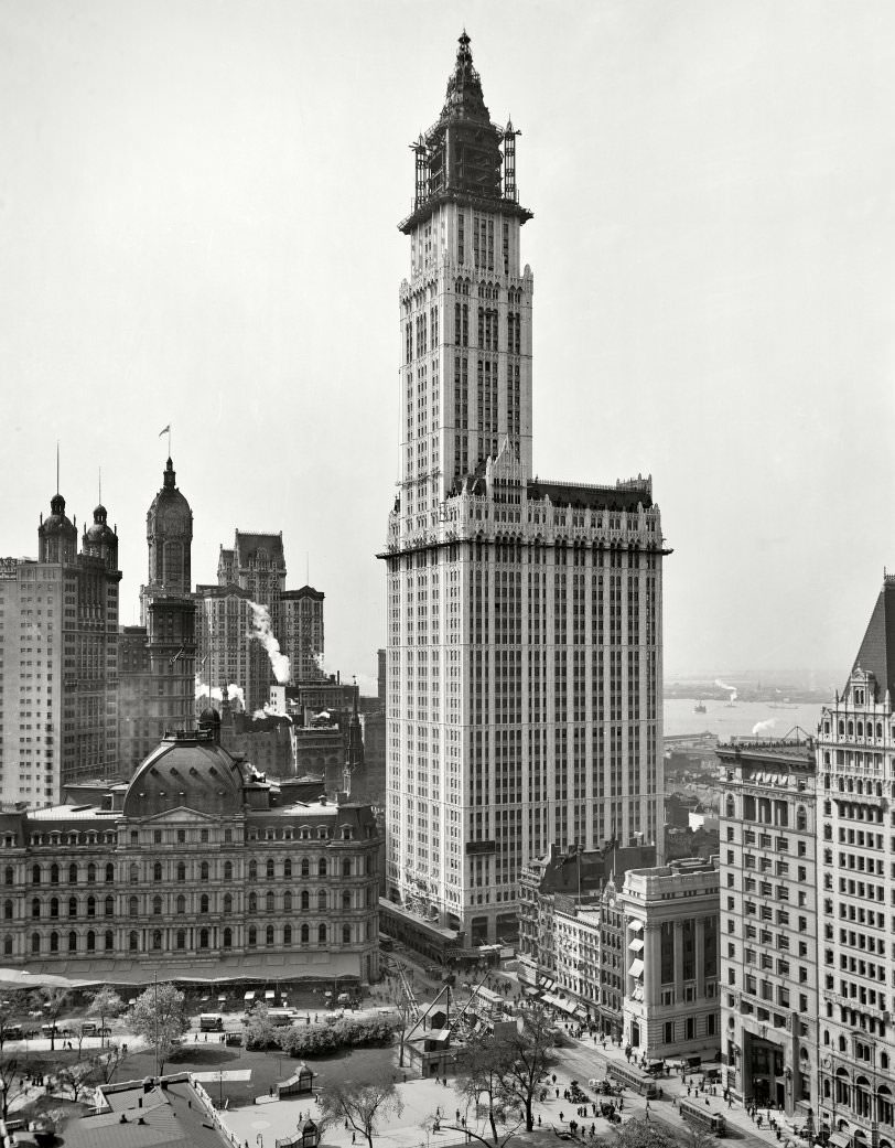 Woolworth Building Underconstruction, 1912. Other Manhattan Landmarks Include City Hall Park And Its Post Office, The Singer Building And The Twin Cupolas Of The Park Row Building.