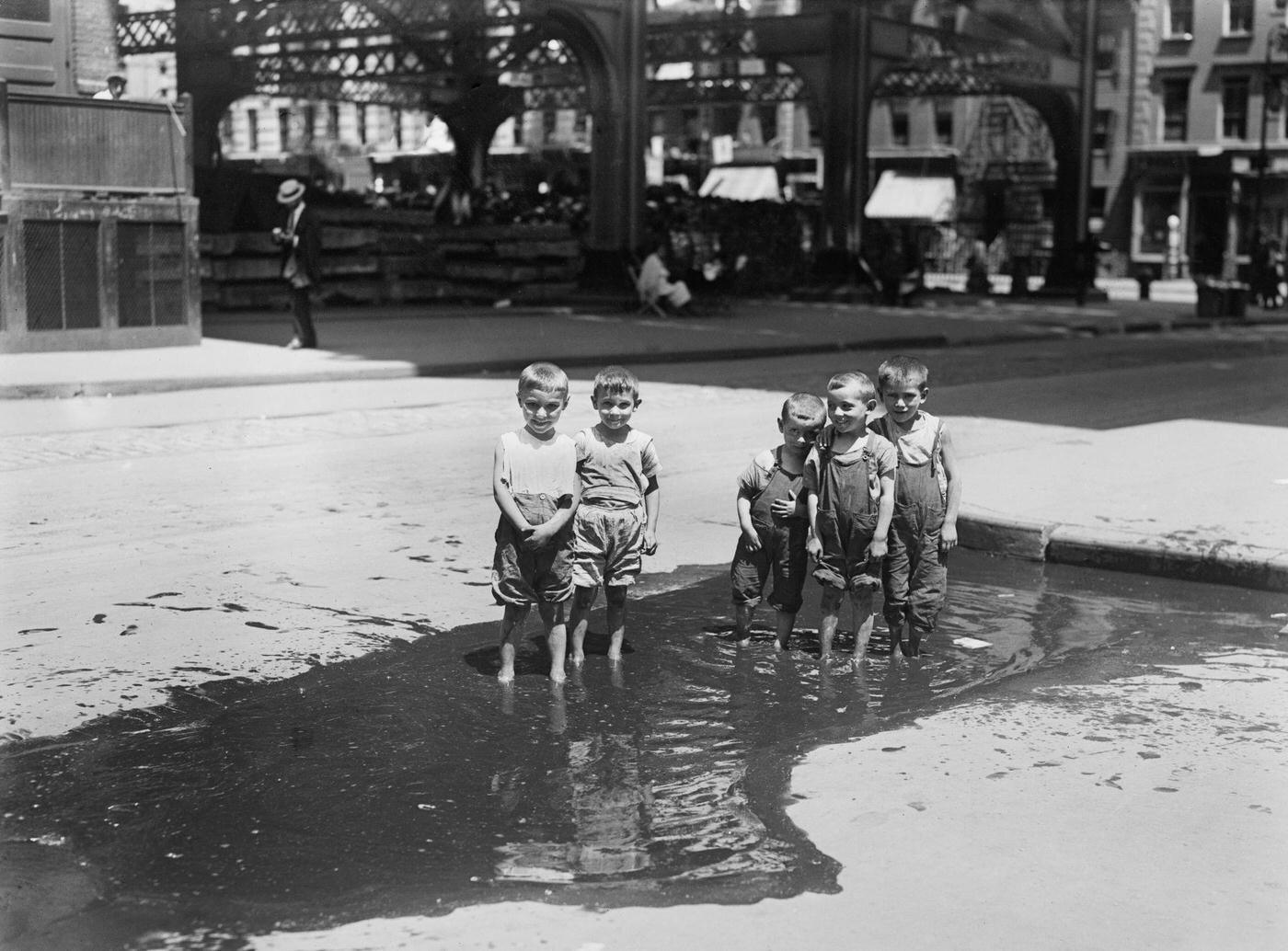 Group Of Small Boys Standing In Street Puddle, New York City, July 1913