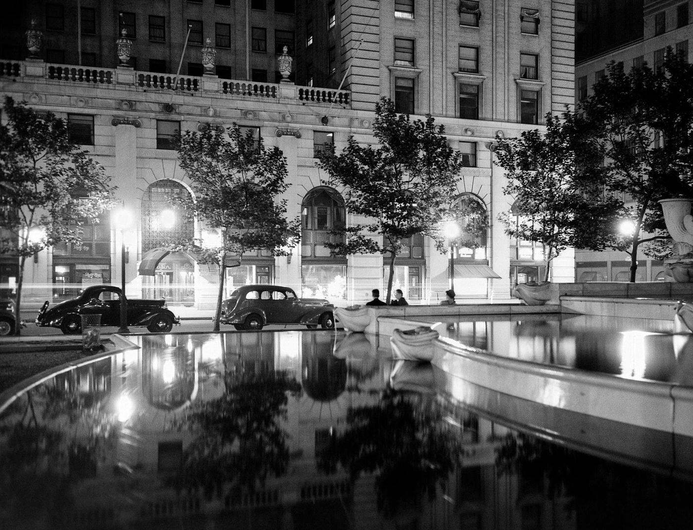 1930S Night Scene 5Th Avenue Tree-Lined Sidewalk, Cars And Anonymous Silhouetted Men Reflecting Water In Pulitzer Fountain, Manhattan, 1930