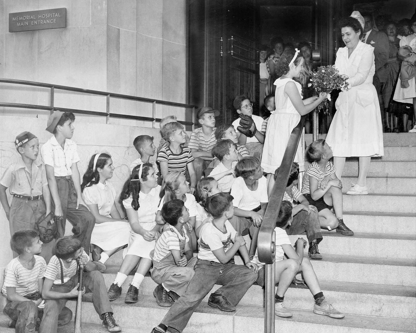Sad Faced Kids Watch Marian Duffy Give Bouquet To Nurse For Ailing Babe Ruth At Memorial Hospital, Manhattan, 1945