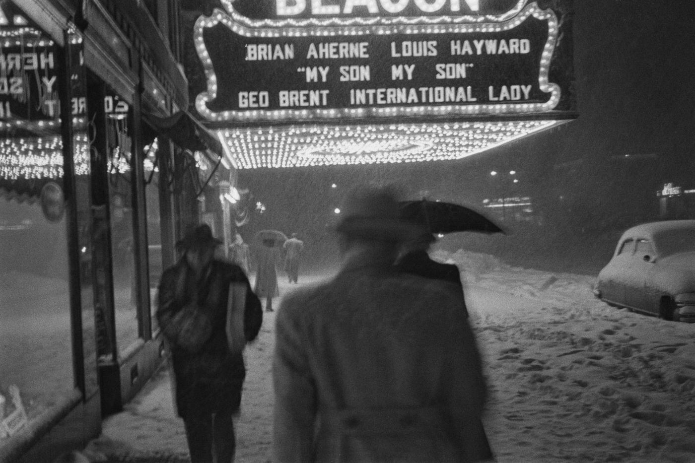 Pedestrians Walk Along The Snow-Covered Sidewalk Outside The Beacon Theatre On Broadway, Manhattan, 1941.