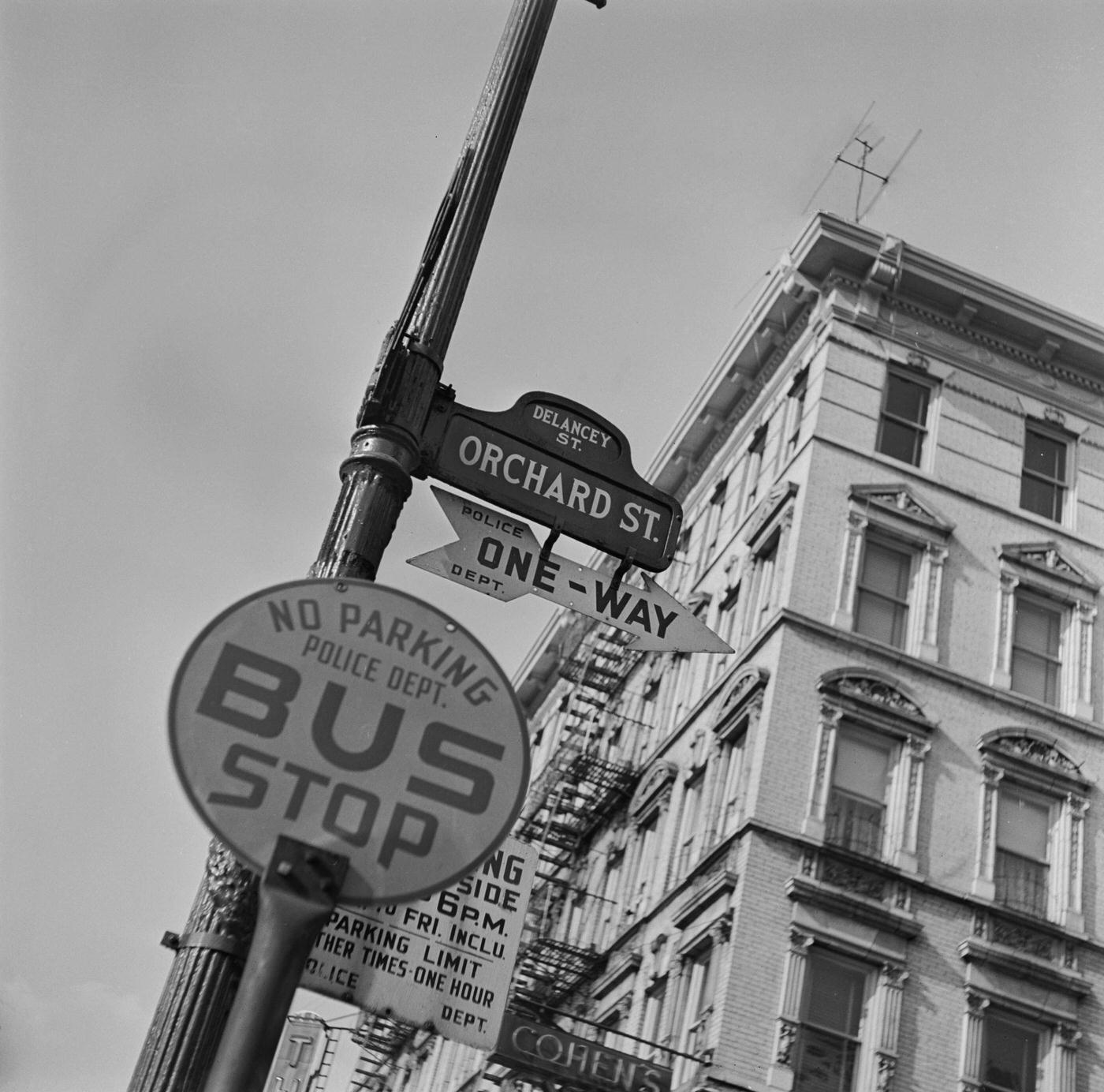 A Street Sign In New York: Bus Stop And Street Sign At Orchard And Delancey Street In Lower East Side, Manhattan, Circa 1950.