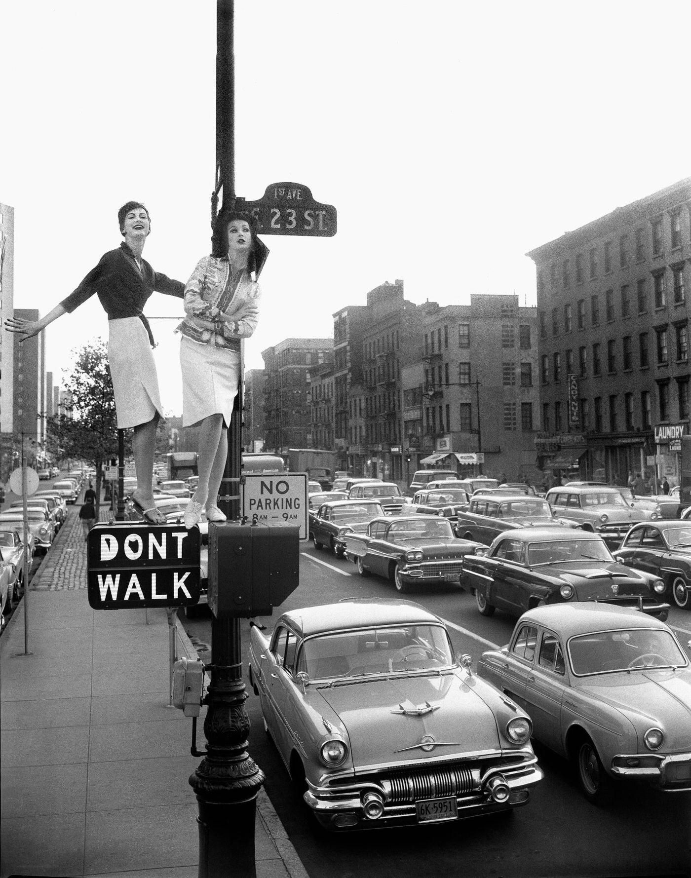 Dell'Orefice &Amp;Amp; Pickering On A 'Don'T Walk' Sign: Models Carmen Dell'Orefice And Betsy Pickering Atop A Traffic Light, Manhattan, 1958.