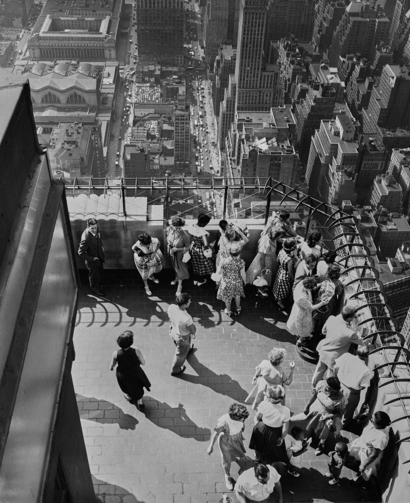 Empire State Building Observatory: Crowd Of People With City And East River Below, Manhattan, 1953