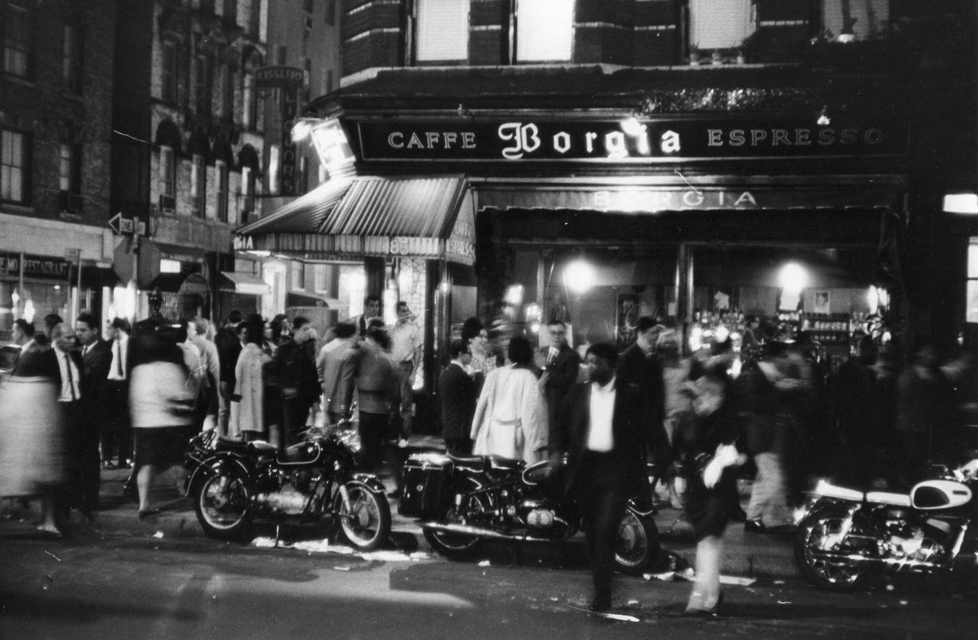 Nighttime View Of Pedestrians In Front Of Cafe Borgia At The Intersection Of Macdougal And Bleeker Streets In Greenwich Village, Manhattan, 1966