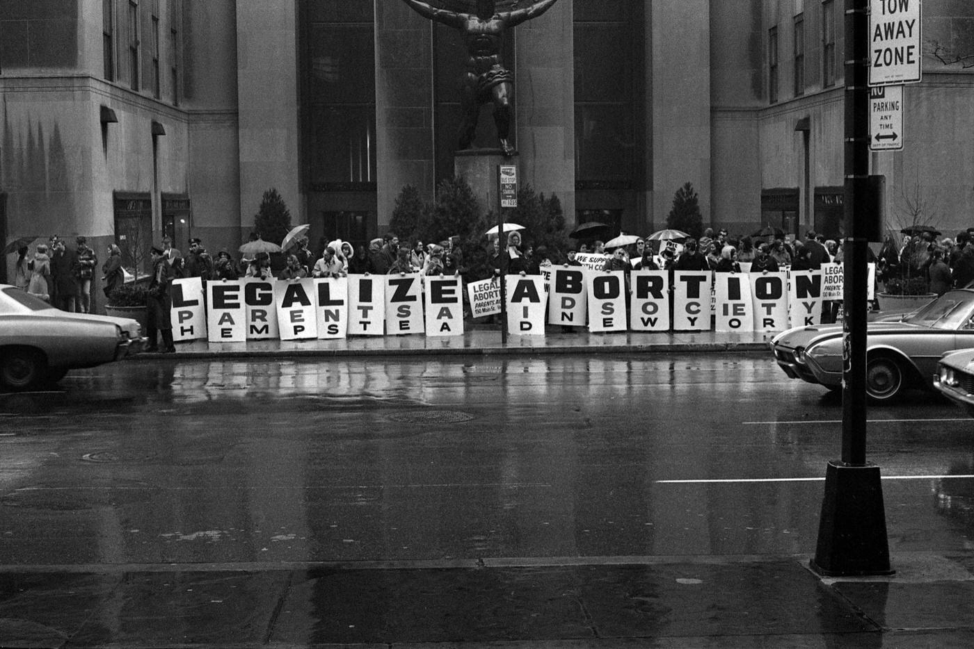 Activists Hold Signs That Read 'Legalize Abortion' In Front Of The Atlas Sculpture At Rockefeller Center, Manhattan, 1968