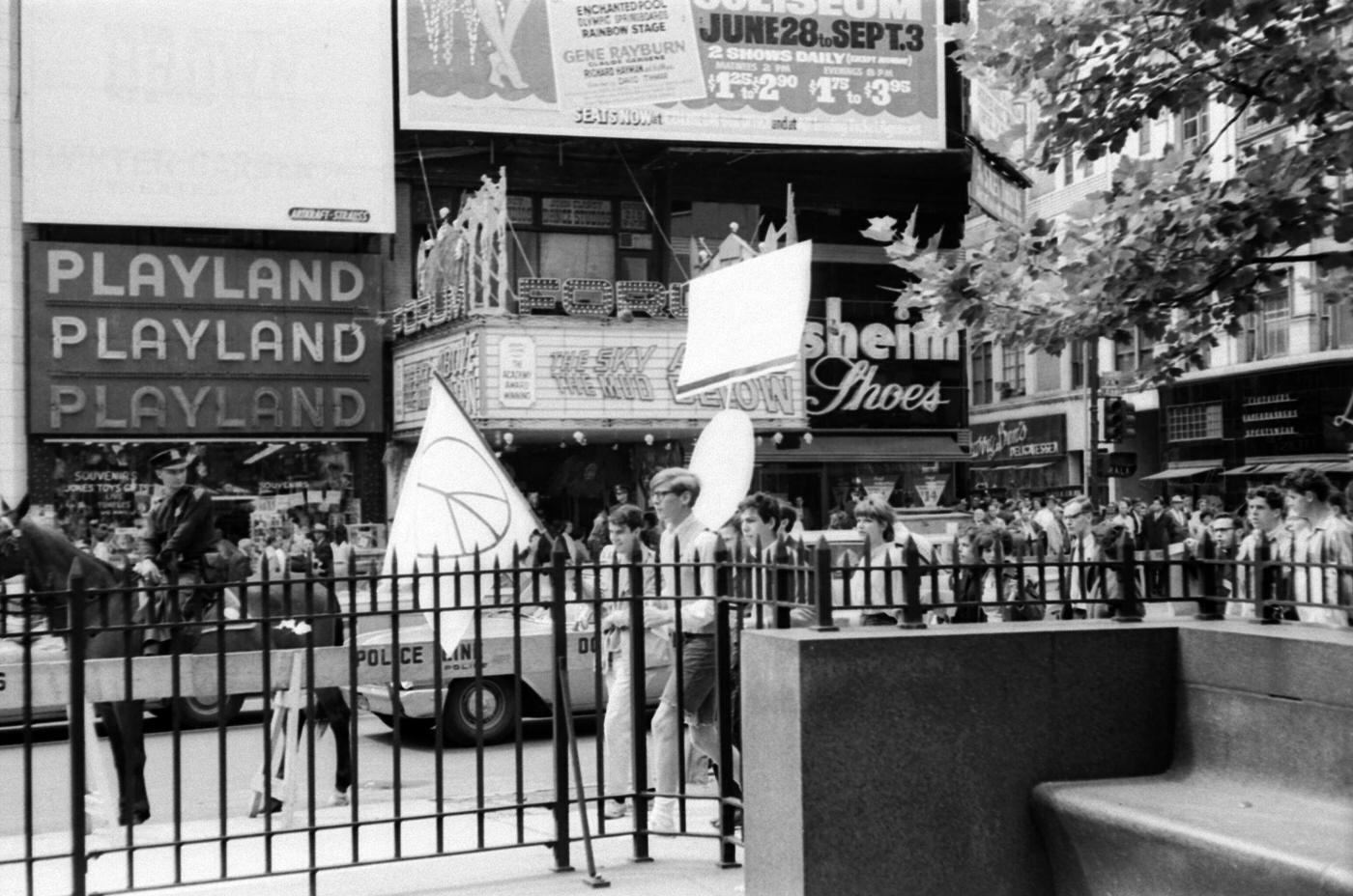 A View Of People Protesting Against War And Atom Bomb Testing By The Playland Arcade In Times Square, Manhattan, 1965.