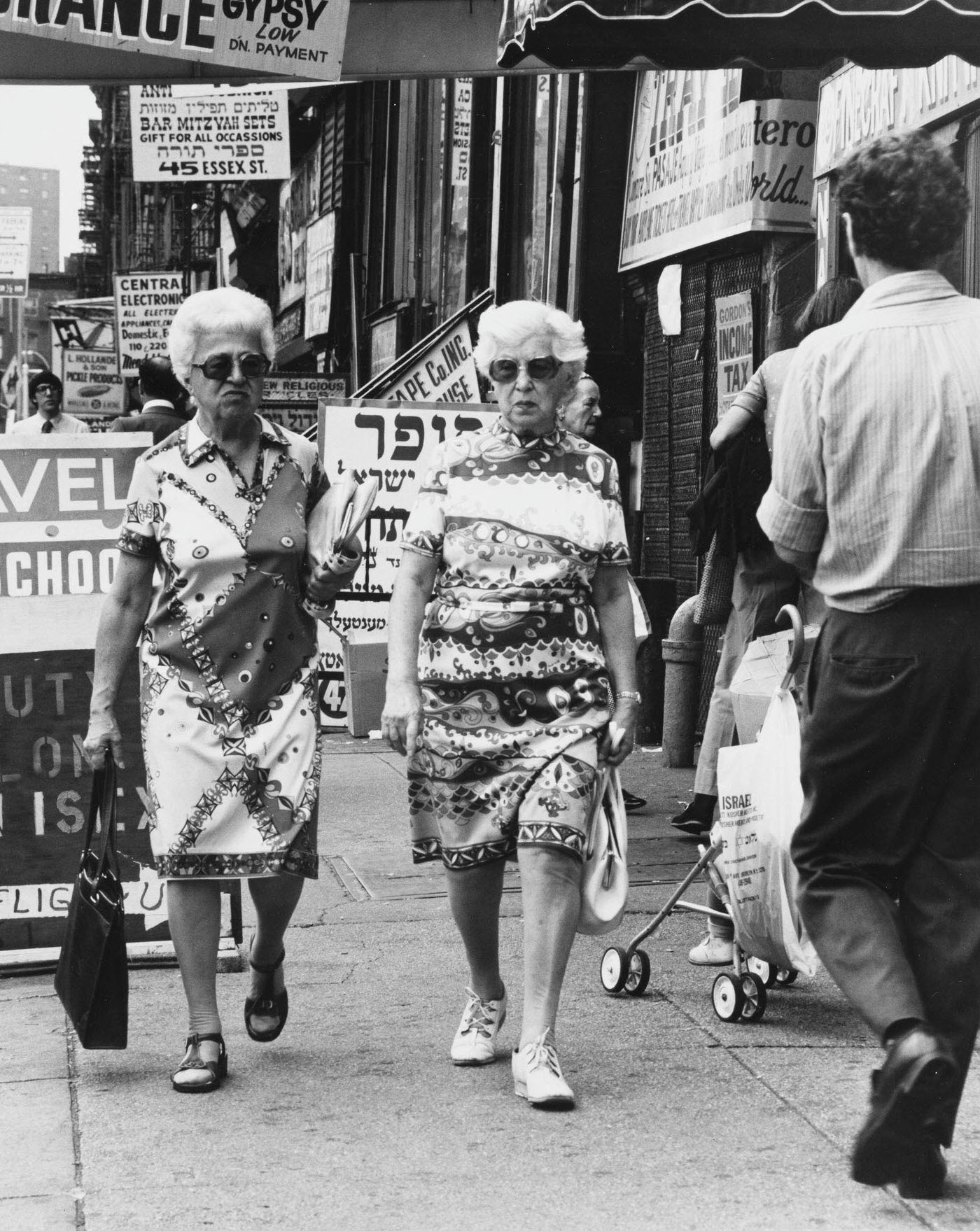 Shoppers Walking On The Sidewalk On Essex Street In The Lower East Side Neighborhood, Manhattan, 1975.