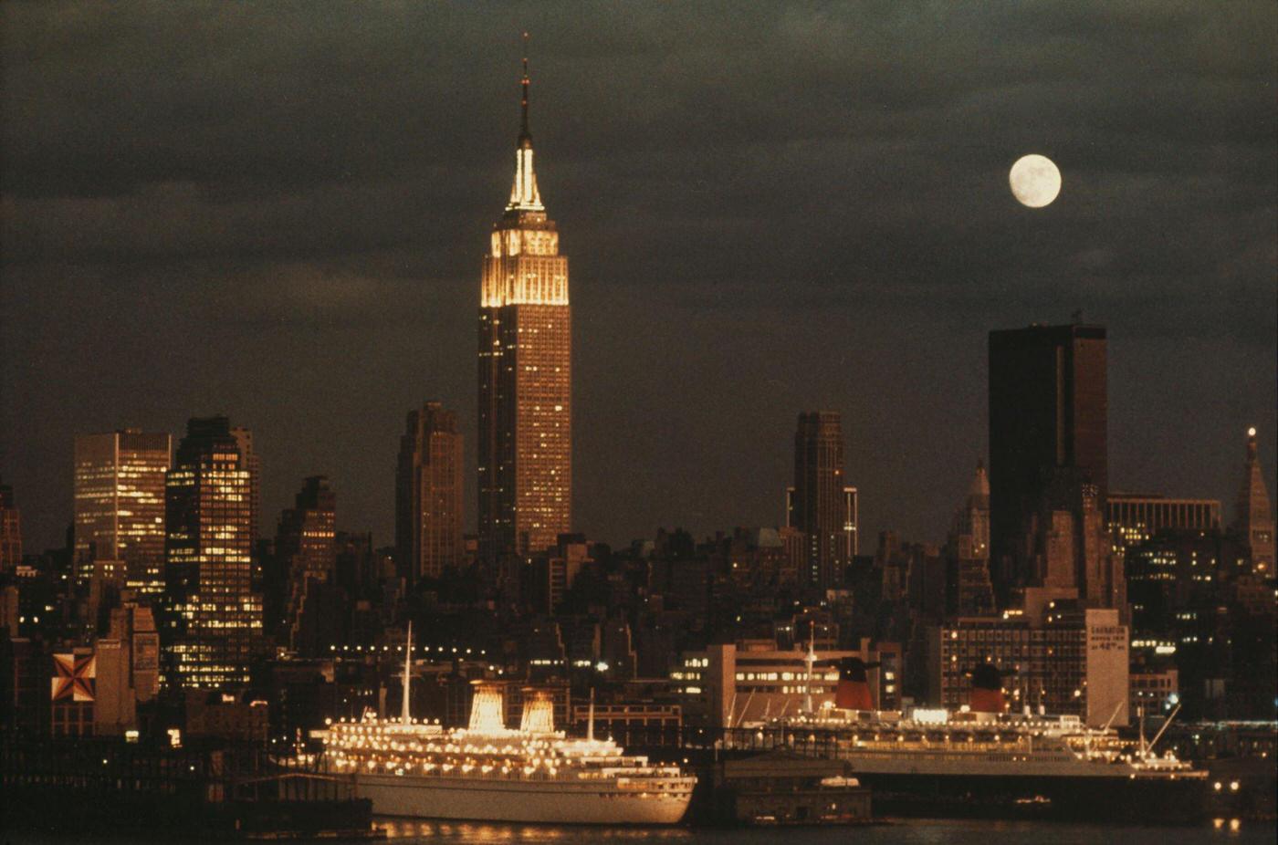 Night View of the Empire State Building, Ships in New York Harbor, and Skyline in Manhattan, 1974.