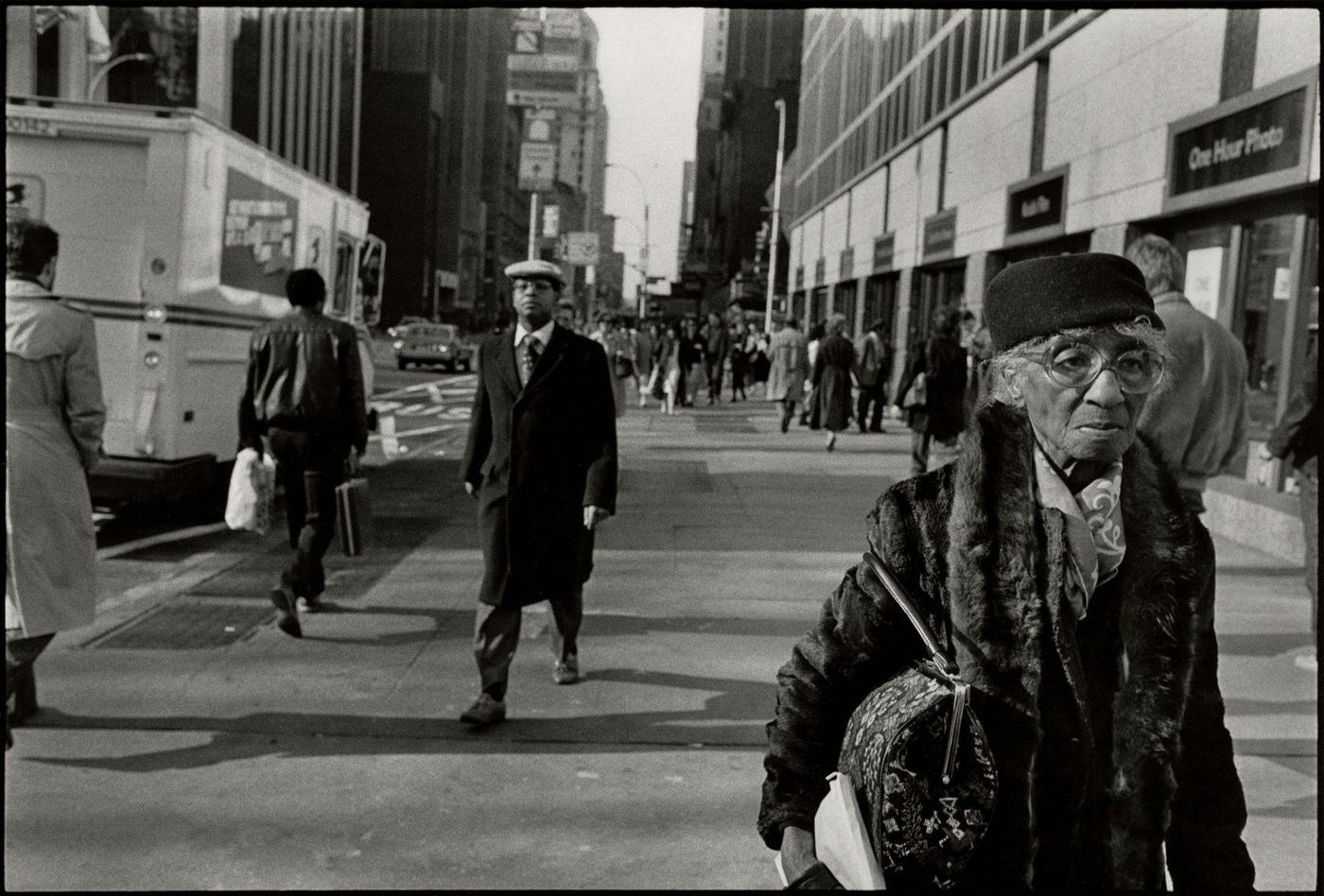 View Of Pedestrians, Including An Elderly Woman, On A Sidewalk In Manhattan, 1987