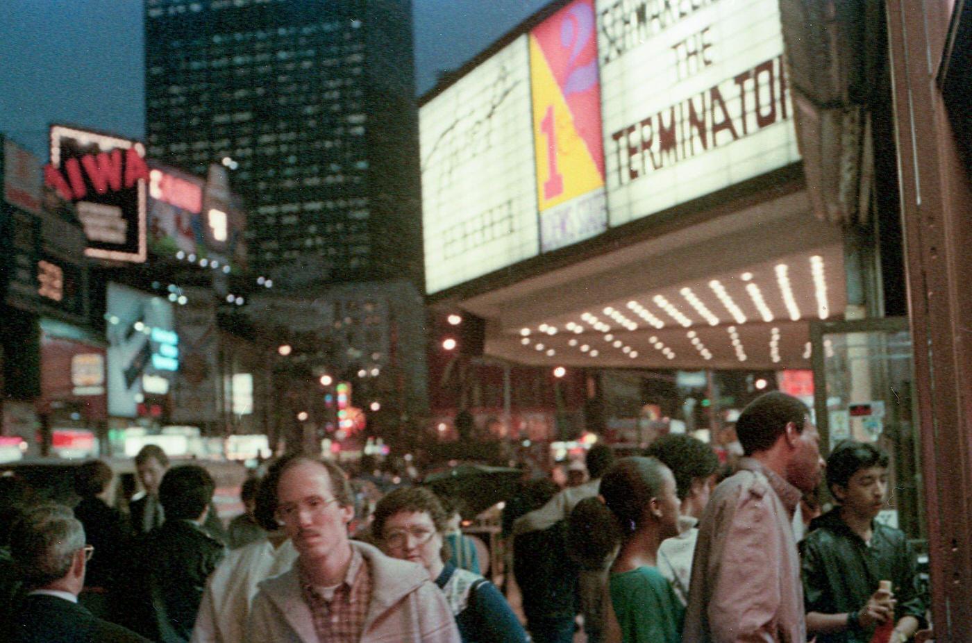 People In Times Square Passing A Theatre Marquee Featuring &Amp;Quot;The Terminator,&Amp;Quot; Manhattan, 1984.