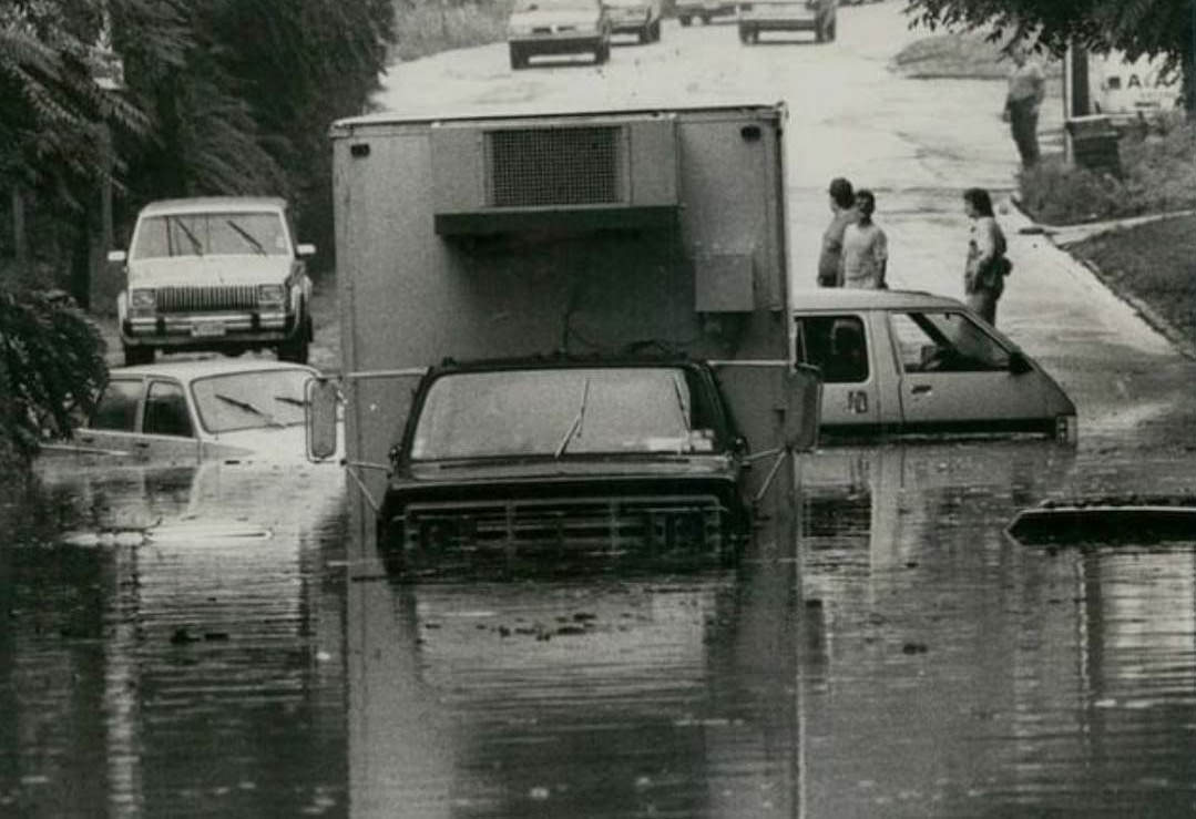 Stalled Trucks And Submerged Cars Sit In The Floodwaters On Amboy Road At Ainsworth Avenue, 1988.
