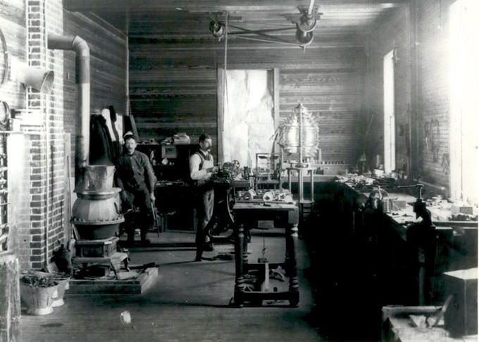 Workmen Repair The Clockwork Mechanism For A Floating Fresnel Lens At The Lighthouse Service Workshop In St. George, 1890S