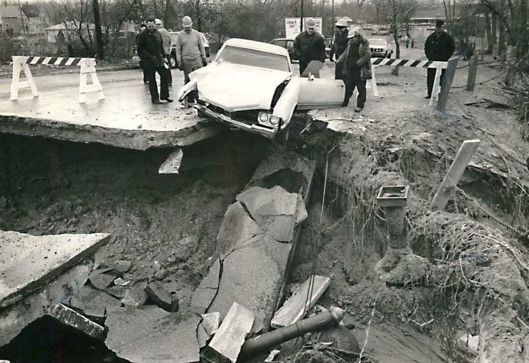 Officials Inspect A Car Hanging Over A Chasm After A Road Collapse, Near Page Avenue Bridge, 1982.