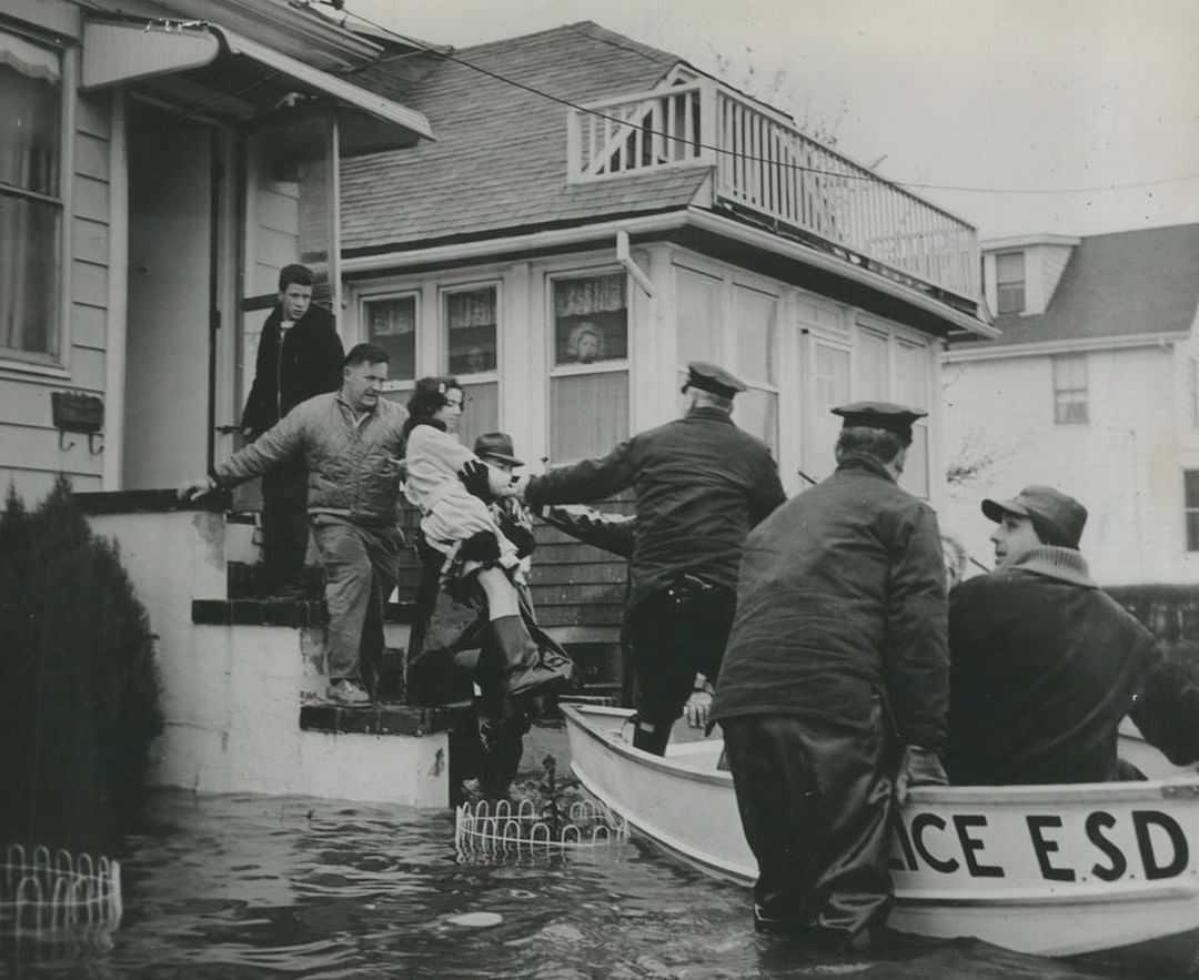 Chief Inspector James J. Mcguire Helps Lift A Girl To Police Boat On Cedar Grove Avenue After Hurricane Donna Hit, 1960.