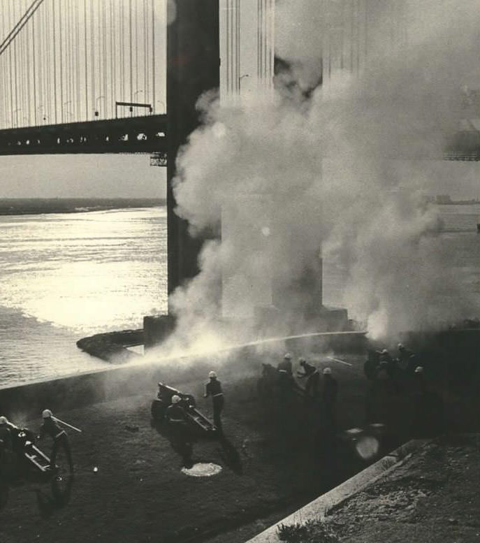 A Battery At Fort Wadsworth Salutes A Navy Ship As It Passes Under The Verrazzano-Narrows Bridge, 1975.