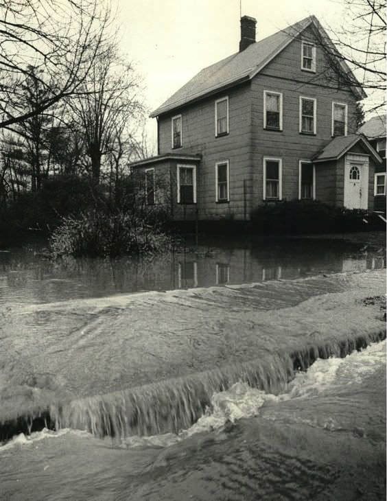 Water Pours Over Sidewalk From Flooded Lot On Amboy Road, Princes Bay, 1983.