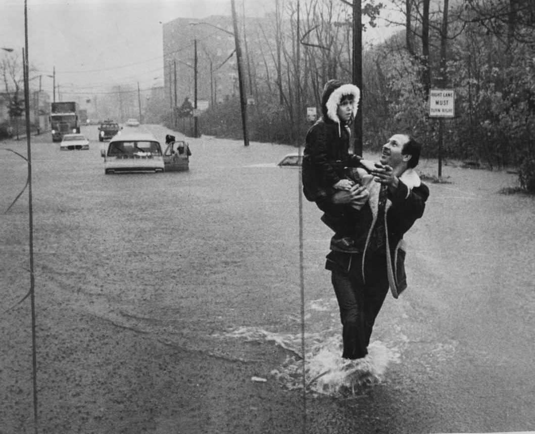 A Motorist Carries A Young Girl From A Half-Submerged Van On Clove Rd., Staten Island, Circa 1977.
