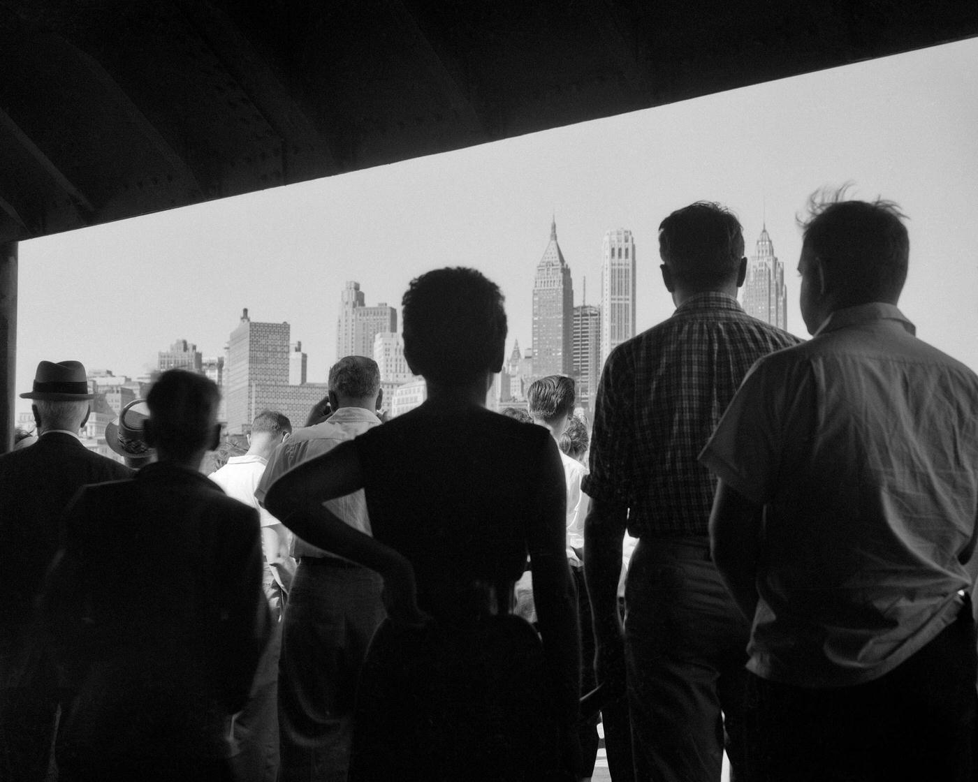 Silhouetted Passengers On Staten Island Ferry Approach Downtown Manhattan.