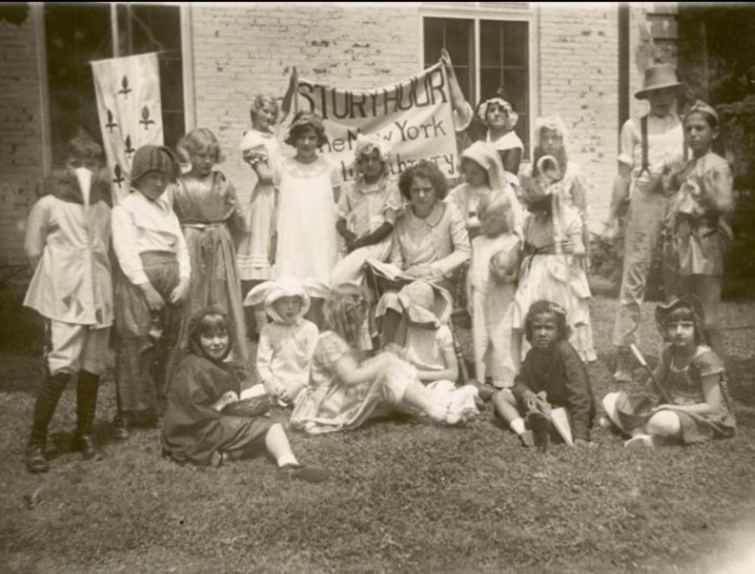 New Dorp: Seated Librarian With Costumed Children At Story Hour, Early 1900S.