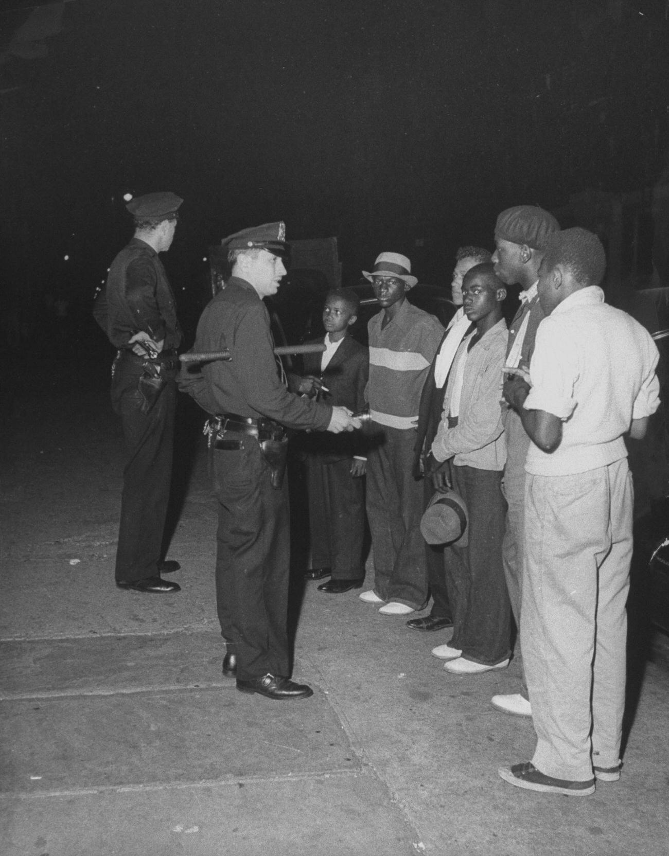 Policemen Stopping And Searching Teenagers For Weapons On A Brooklyn Street.