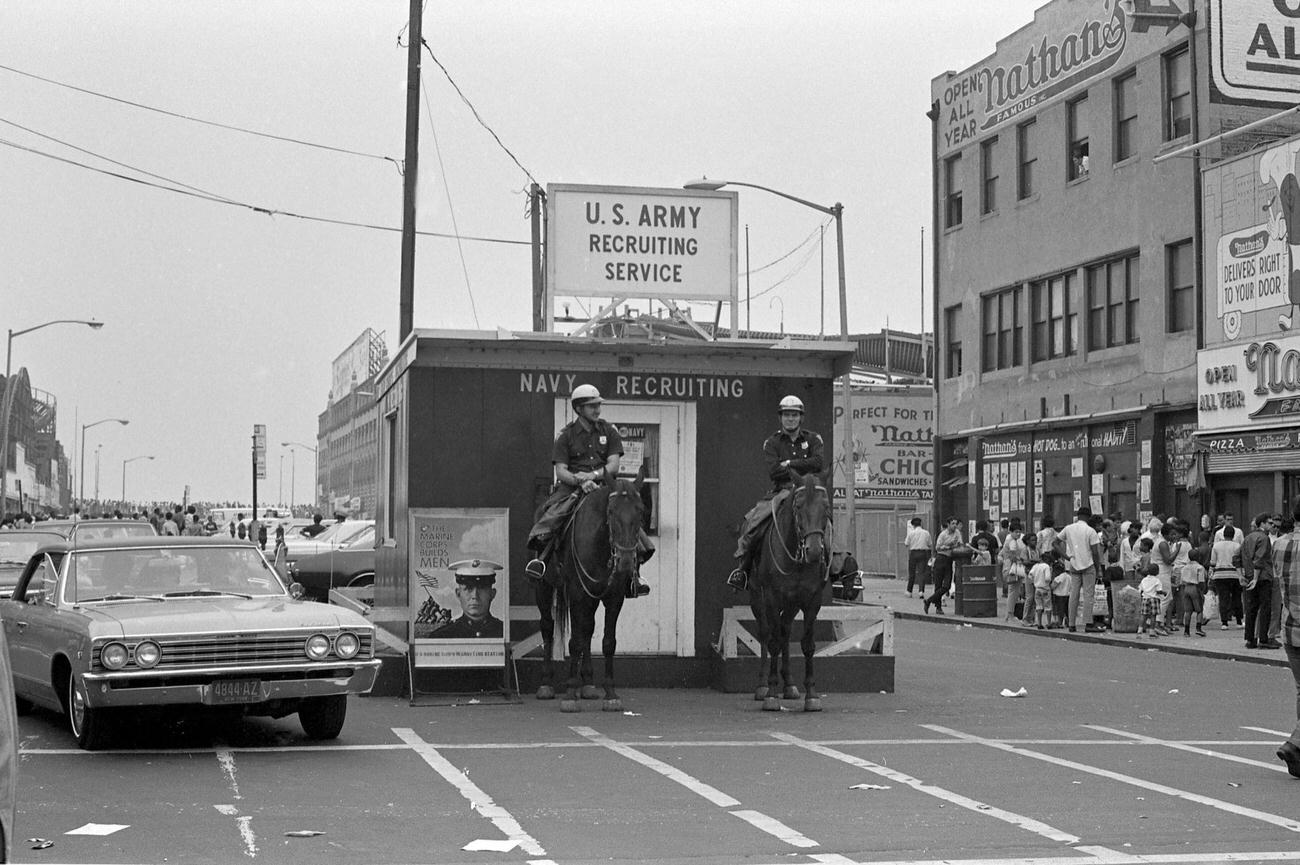 Mounted Police Officers Stand In Front Of An Army And Navy Recruiting Station At Coney Island, Brooklyn, 1968.
