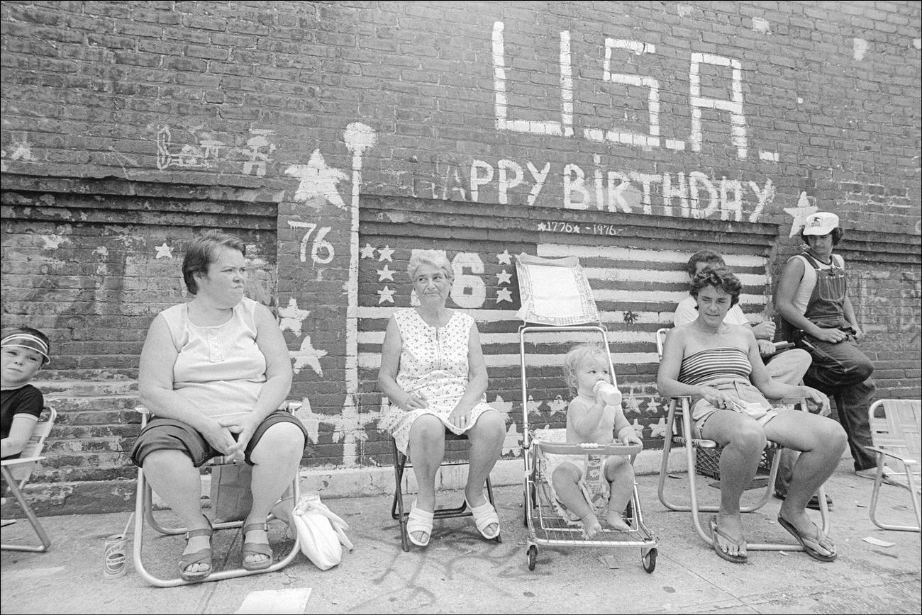 Residents Of Bushwick Watch Kids Play In Open Fire Hydrants On A Hot Summer Day, Brooklyn, 1977