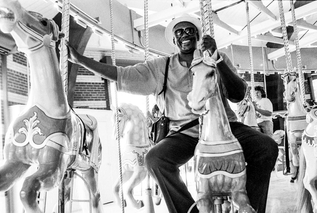 Randy Weston Rides A Carousel At Coney Island In Brooklyn, 1991