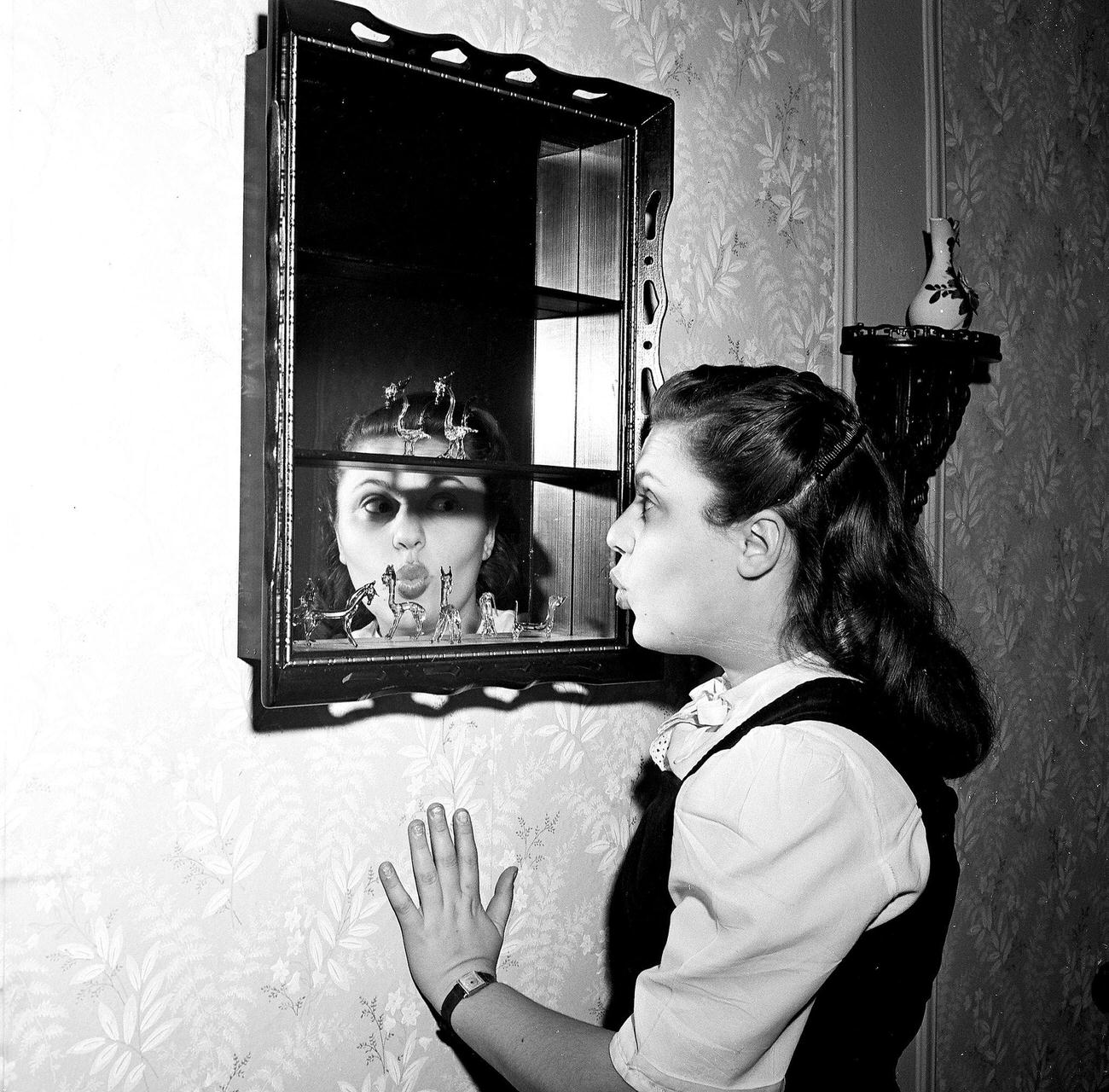 Woman Puckering Lips In Front Of A Hallway Mirror, 1945