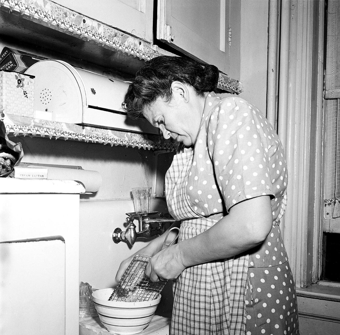 Woman Using A Grater While Cooking In The Kitchen, 1945