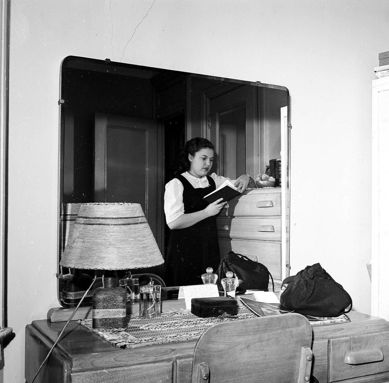 Young Woman Reading A Book Reflected In A Mirror, 1945