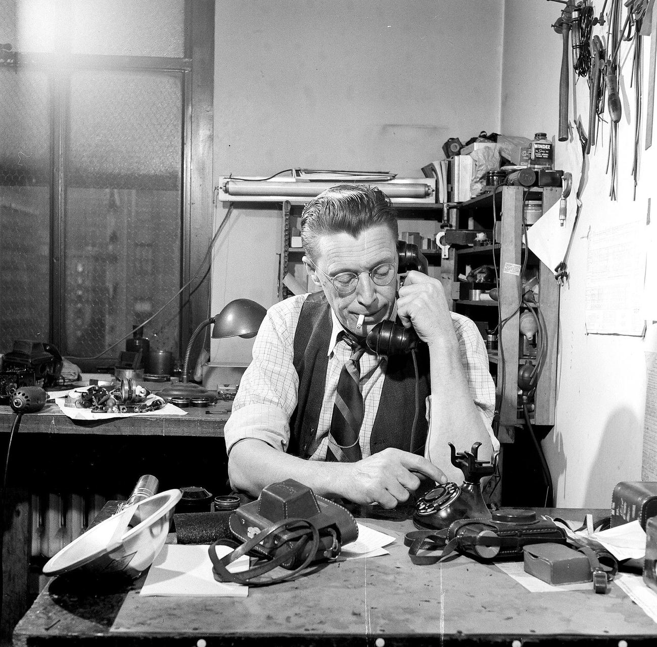 Man Talking On Telephone In Camera Repair Shop, 1946