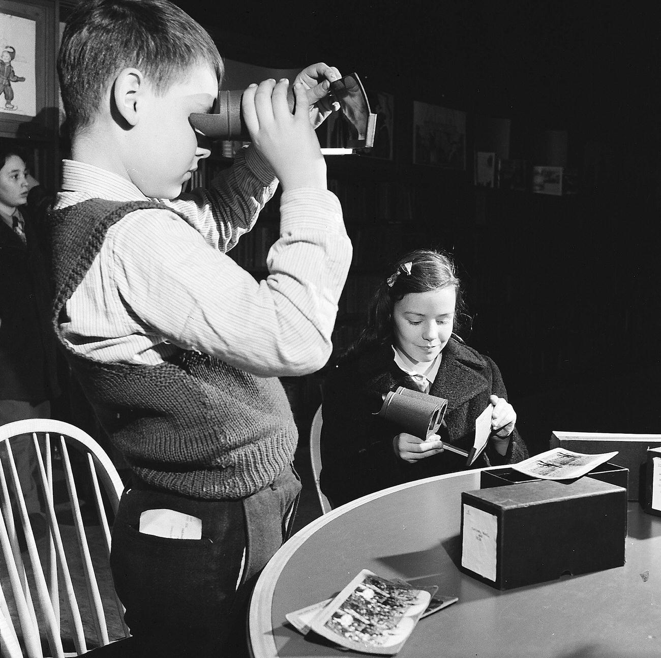 Boy And Girl Exploring Stereographs At Library, 1947