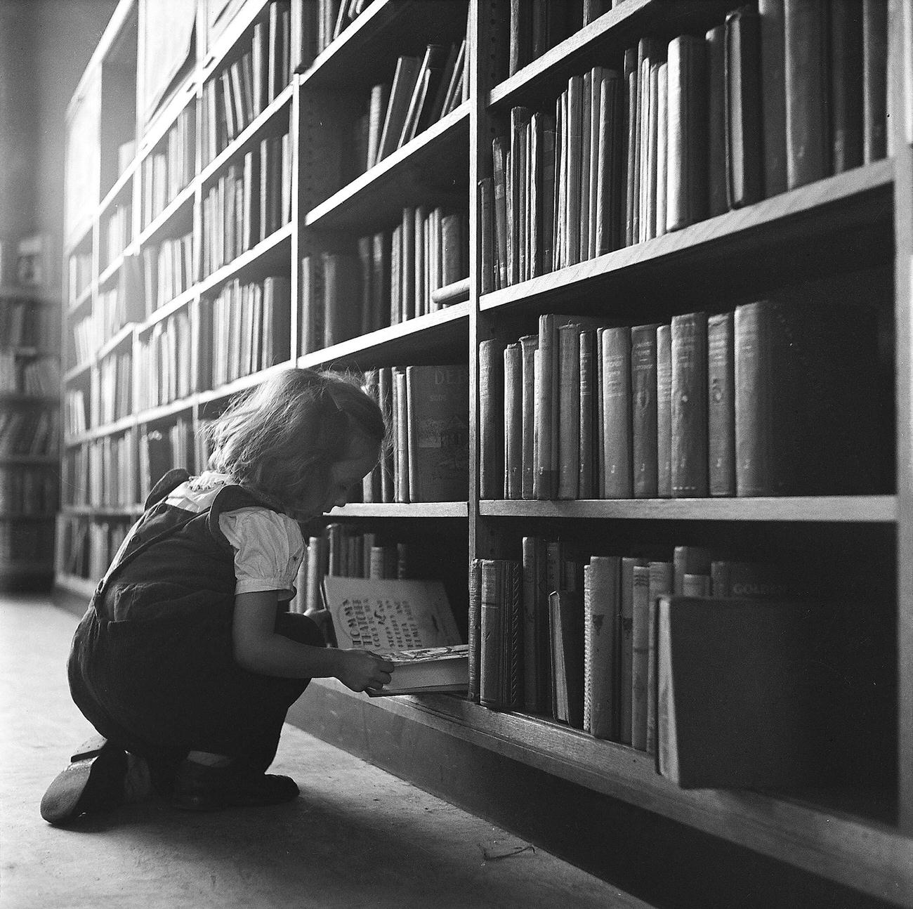 Girl Picks Books From Shelf, 1947