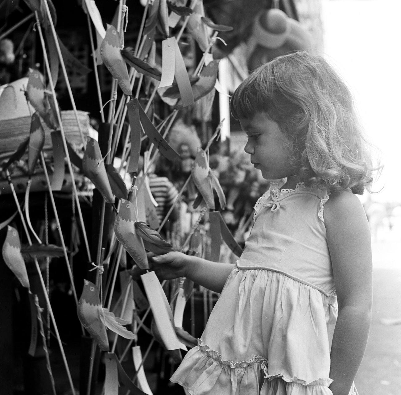 Girl Picking Toy From Storefront Vendor, 1948