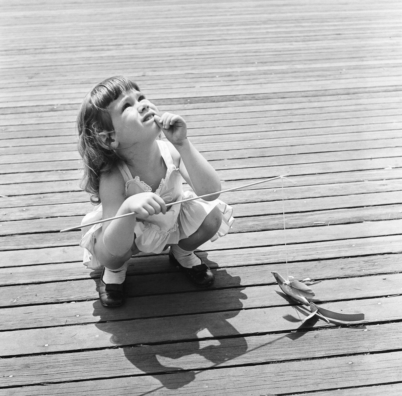 Young Girl Holds A Whirling Bird Toy On Coney Island Boardwalk, 1948