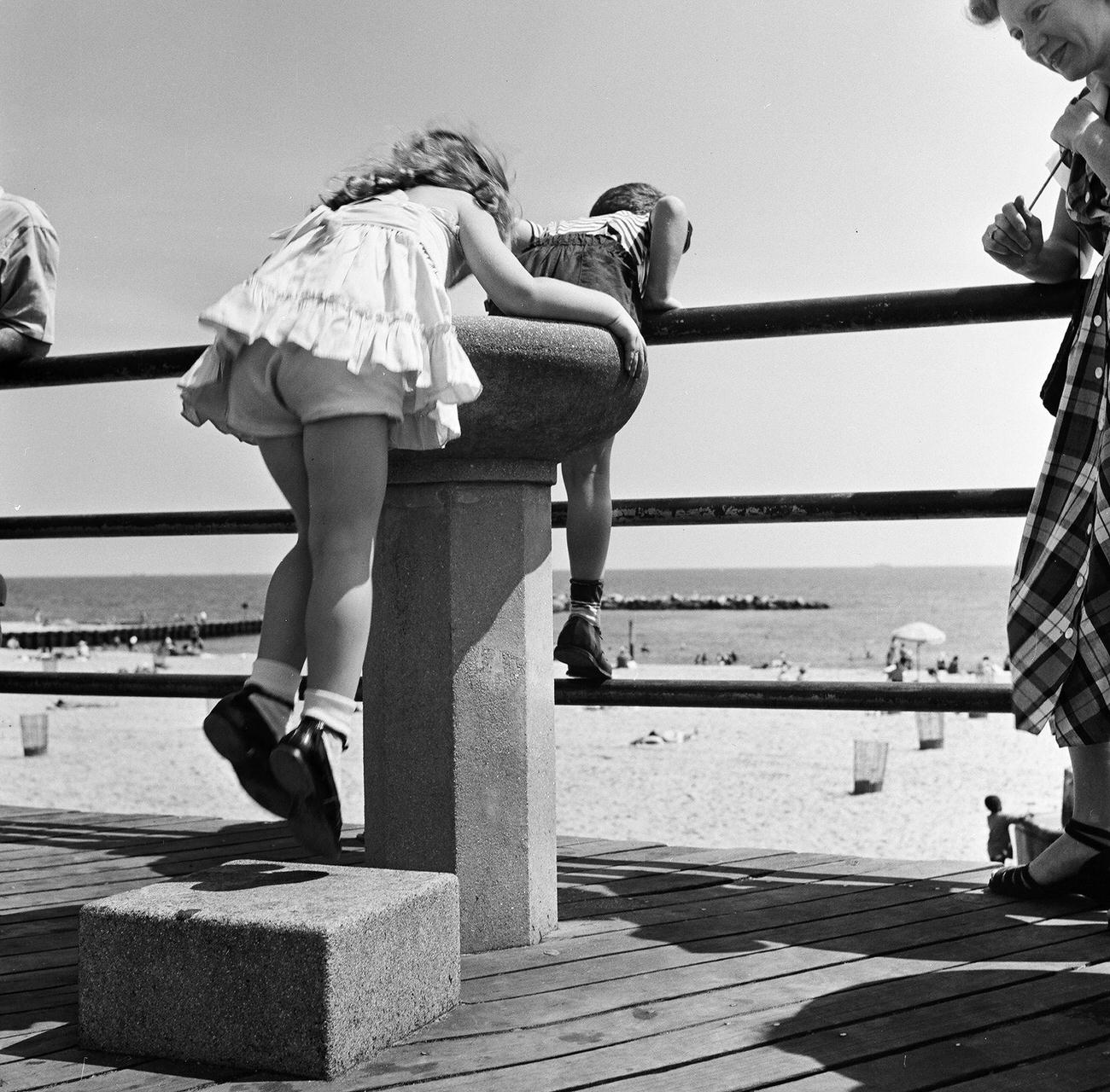 Girl Drinks From Water Fountain As Family Watches On Coney Island Boardwalk, 1948
