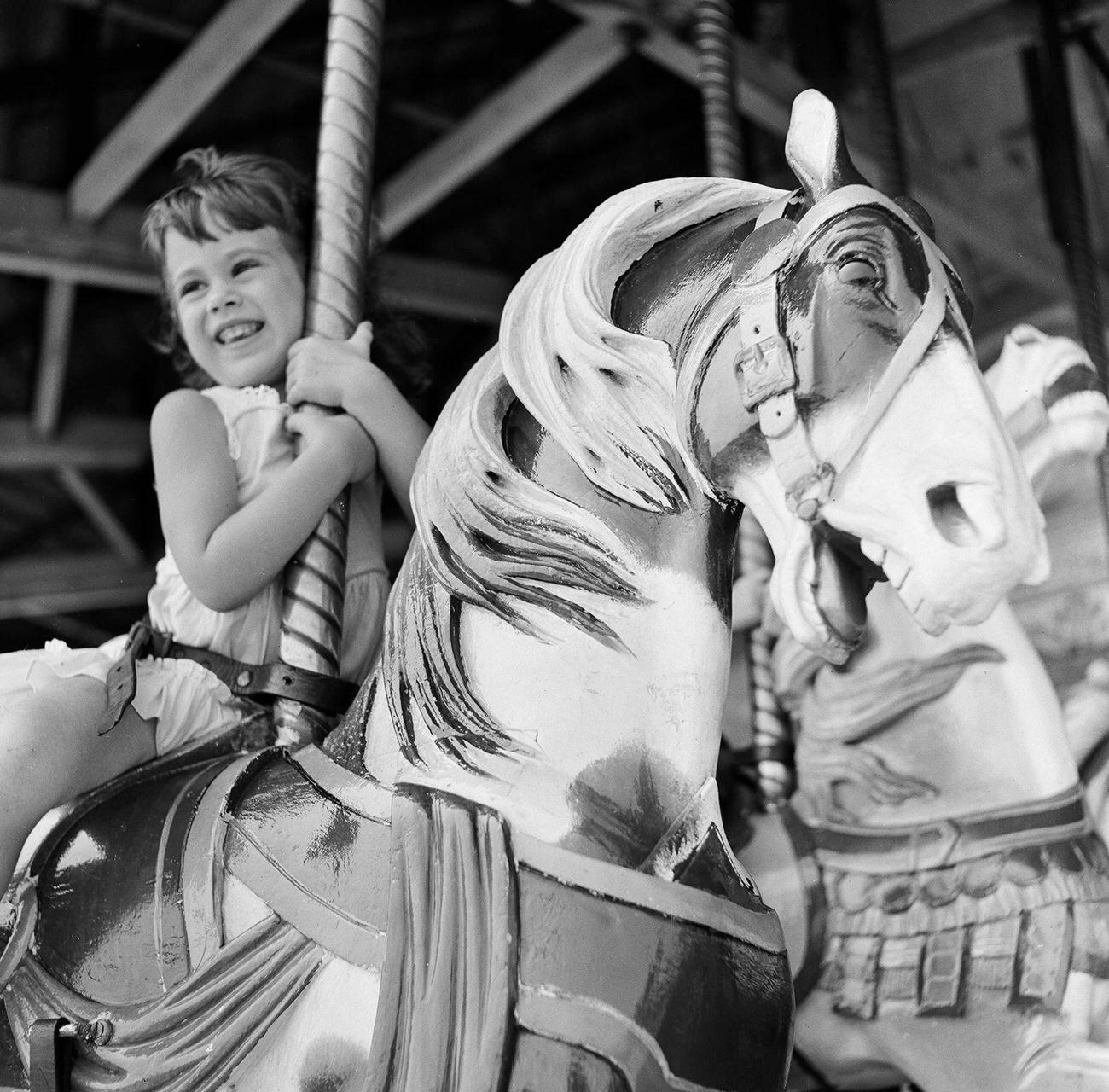 Young Girl Enjoys A Carousel Ride At Coney Island, 1948