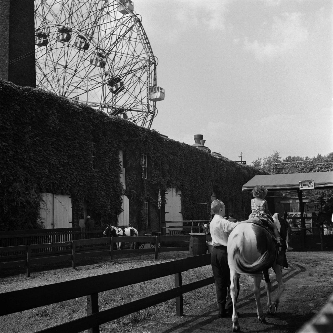 Children Riding Horses Near Big Wheel, 1946